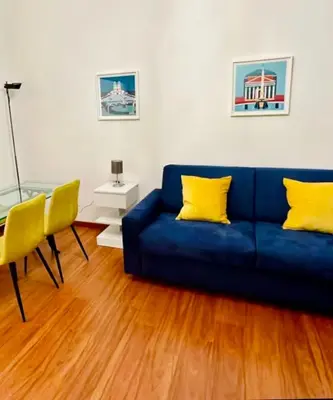 a living room with a blue couch and a glass table at Comodo appartamento a pochi passi dalla fermata Porta Metronia Metro C in Rome