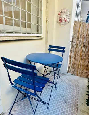 two blue chairs and a table in a room at Comodo appartamento a pochi passi dalla fermata Porta Metronia Metro C in Rome