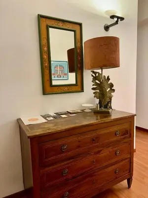 a dresser with a mirror and a lamp on it at Comodo appartamento a pochi passi dalla fermata Porta Metronia Metro C in Rome