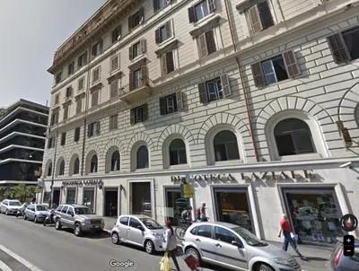 a large building with cars parked in front of it at Cunabu Apartments in Rome