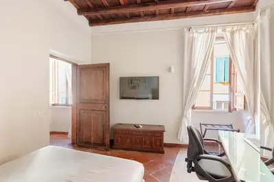a bedroom with a bed and a desk and a window at BQA San Crisogono Apartments Rome-Trastevere in Rome