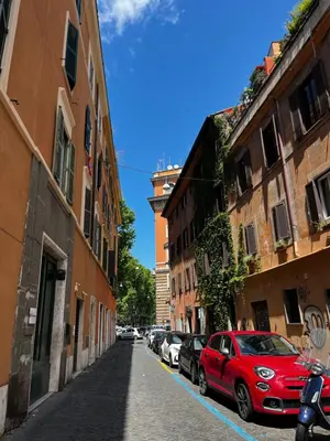 a red car parked on a street next to buildings at BQA San Crisogono Apartments Rome-Trastevere in Rome