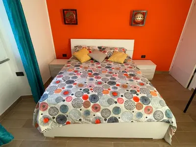 a bed in a room with an orange wall at Zangàl al Vaticano - Metro Cornelia in Rome