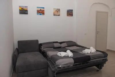 a bed and a chair in a room at DOMVS Ginori Testaccio in Rome