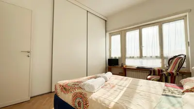 a bedroom with a bed and a desk and windows at BaccaLia Home in Rome