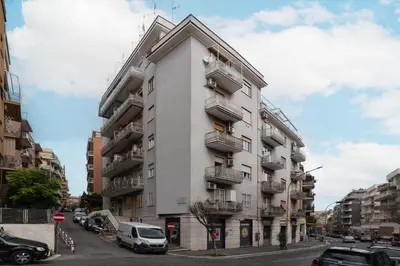 a tall white building with balconies on a city street at GuestHost - Monteverde Quattro Venti Apartment in Rome