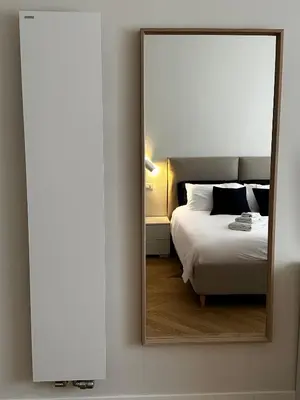 a mirror hanging on a wall next to a bed at Giulia’s Corner in Rome