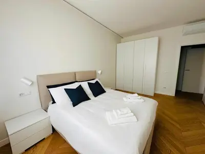 a bedroom with a white bed and a white cabinet at Giulia’s Corner in Rome
