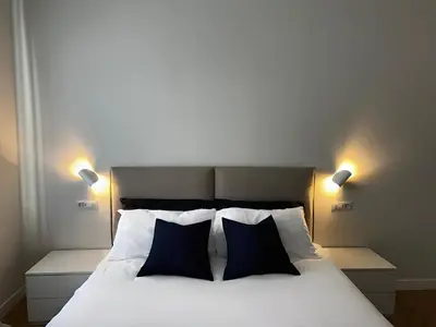 a bedroom with a white bed with two blue pillows at Giulia’s Corner in Rome