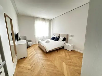 a white bedroom with a bed and a window at Giulia’s Corner in Rome