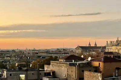 a view of a city at sunset with buildings at Adventura Penthouse in Rome