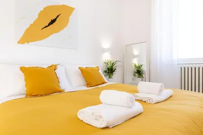 a bedroom with a large yellow bed with towels on it at Adventura Penthouse in Rome