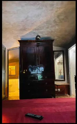 a bedroom with a dark wooden cabinet and a ceiling at Apartamento loft ingresso independente central zona san lorenzo in Rome