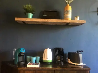 a wooden shelf with various appliances on a table at Guest Art Trastevere Station with AC in Rome