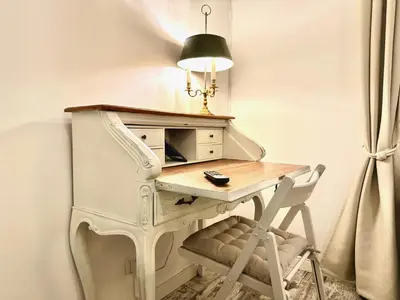 a desk with a chair and a desk with a lamp at Vacanze Romane Colosseum in Rome