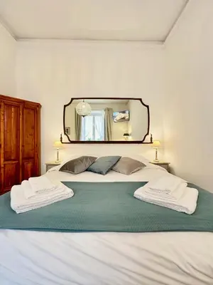 a bedroom with a large bed with a mirror on the wall at Vacanze Romane Colosseum in Rome