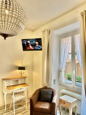 a living room with a chair and a tv on the wall at Vacanze Romane Colosseum in Rome
