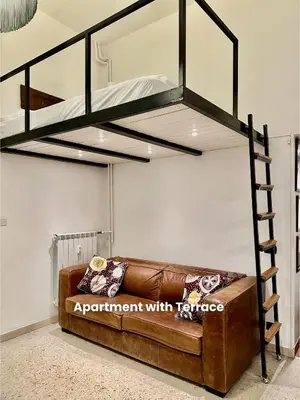 a loft bed with a couch in a room at Vacanze Romane Colosseum in Rome