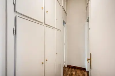 a hallway with white cabinets and wood floors at Borgo Pio Passetto Papale in Rome