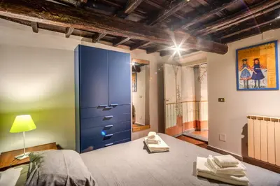a bedroom with a blue cabinet and a bed at Cartari Apartment in Rome