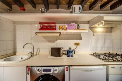 a kitchen with a sink and a washing machine at Cartari Apartment in Rome