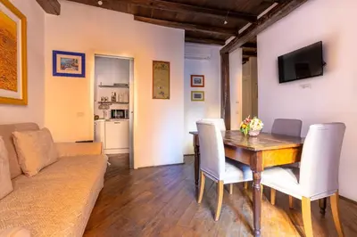 a living room with a wooden table and a couch at FIORE home Rome Center Campo dè Fiori in Rome
