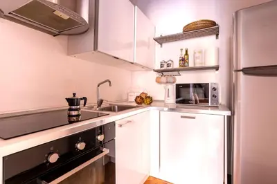 a small kitchen with white cabinets and a sink at FIORE home Rome Center Campo dè Fiori in Rome