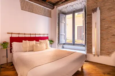 a bedroom with a large bed with a red headboard at FIORE home Rome Center Campo dè Fiori in Rome