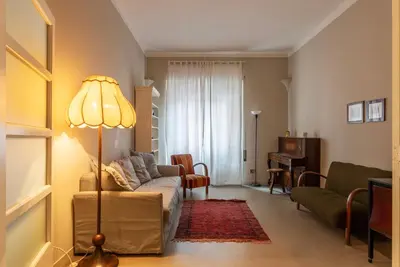 a living room with a couch and a lamp at GuestHost - Piazza Bainsizza Elegant Apartment in Rome