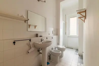 a white bathroom with a sink and a toilet at GuestHost - Piazza Bainsizza Elegant Apartment in Rome