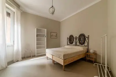 a bedroom with a bed in a white room at GuestHost - Piazza Bainsizza Elegant Apartment in Rome