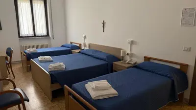 three beds in a room with blue sheets at Casa Per Ferie Casa Cabrini in Rome