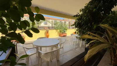 a patio with a table and chairs and plants at Casa Per Ferie Casa Cabrini in Rome
