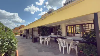 a patio with white chairs and tables on a building at Casa Per Ferie Casa Cabrini in Rome