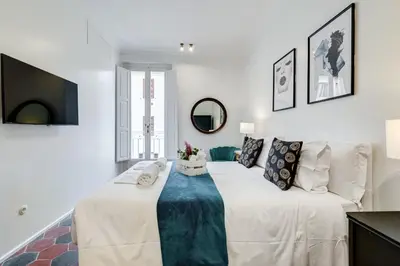 a bedroom with a large white bed and a couch at Klioos Apartment Testaccio in Rome
