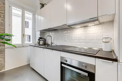 a white kitchen with a sink and a stove at Klioos Apartment Testaccio in Rome