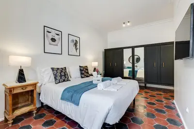 a bedroom with a large white bed and a table at Klioos Apartment Testaccio in Rome