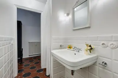 a white bathroom with a sink and a mirror at Klioos Apartment Testaccio in Rome
