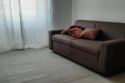 a brown couch with two pillows sitting in a living room at Caterina Apt San Lorenzo 2camere in Rome
