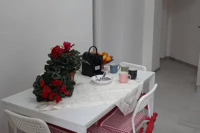 a white table with flowers and fruit on it at Caterina Apt San Lorenzo 2camere in Rome