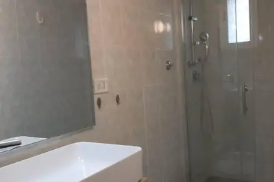 a bathroom with a shower and a sink and a mirror at Caterina Apt San Lorenzo 2camere in Rome