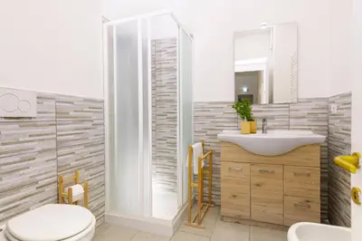 a bathroom with a sink and a toilet and a mirror at San Giovanni Home in Rome