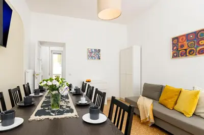 a dining room with a table and a couch at San Giovanni Home in Rome