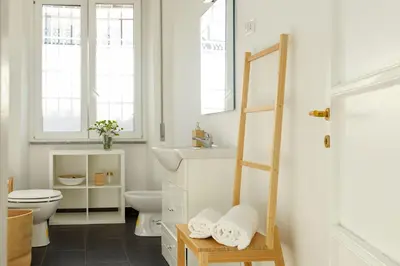 a white bathroom with a toilet and a sink at San Giovanni Home in Rome