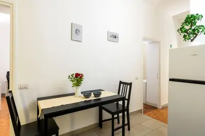 a dining room table and chairs with a vase of flowers on it at San Giovanni Home in Rome