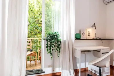 a room with a window and a desk with a plant at SkyView Home in Rome