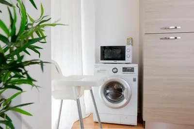 a laundry room with a washing machine and a microwave at SkyView Home in Rome