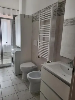 a white bathroom with a toilet and a sink at Home Sweet Home Tiburtina Station in Rome