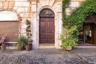 a building with a large wooden door with plants at Roma Coronari a 2 minuti da piazza Navona in Rome