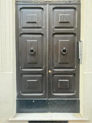 a large wooden door in the side of a building at Pietra Apartment,Colosseo in Rome